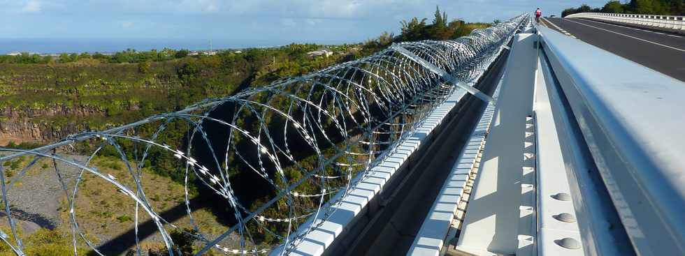 7 juillet 2013 - St-Pierre - Barbelés installés le long de la corniche caniveau du pont sur le Bras de la  Plaine